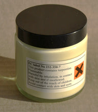 Load image into Gallery viewer, Jar with a black lid and warning label on a beige background
